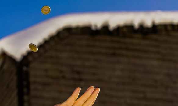 shallow focus photography of person catching two gold colored coins